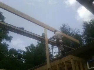 Carpenter setting a ridge beam over a new addition frame — Ice Dam Removal by Roofing Brothers in Wood Lake