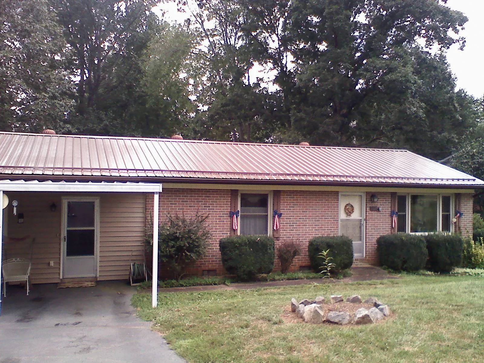 Bronze metal roof and carport on a brick ranch home — Roof Repair work by our crew in Wood Lake